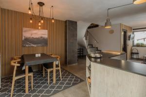 una cucina e una sala da pranzo con tavolo di Klimahouse North a Campitello di Fassa