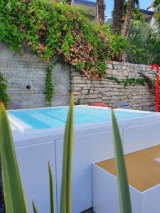 a swimming pool in front of a brick wall at Visioni Lake View Boutique Rooms & Breakfast - Adults Friendly in Riva del Garda