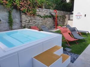 una piscina con sedie e tavolo di Visioni Lake View Boutique Rooms & Breakfast - Adults Friendly a Riva del Garda