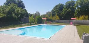 a swimming pool in a yard with umbrellas at Camping de l'Ill in Mulhouse