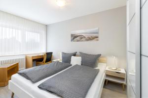 Habitación blanca con cama y escritorio en Ostsee-Quartier 7 Gutenbergstraße 5 APPARTO Grömitz, en Grömitz