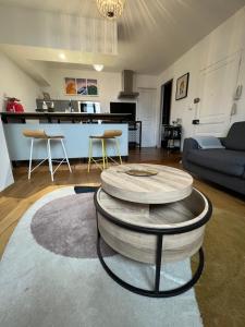ein Wohnzimmer mit einem Couchtisch und einer Küche in der Unterkunft Brive centre, superb appartement en face du Marché Primé in Brive-la-Gaillarde