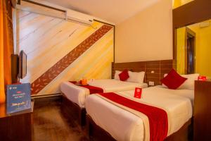 a hotel room with two beds with red accents at Hotel Snowland in Pokhara