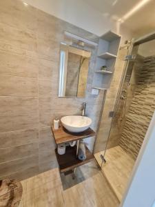 uma casa de banho com um lavatório e um chuveiro em Apartments Primo Maggio em Piran