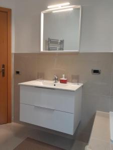 La salle de bains est pourvue d'un lavabo blanc et d'un miroir. dans l'établissement Oasi home, à Casteldaccia