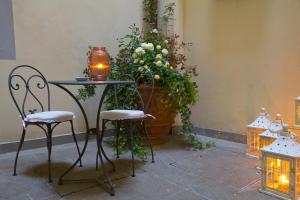 a table and chairs with a potted plant and lights at Residence Hilda in Florence
