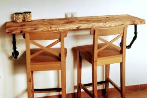 una mesa de madera con 2 sillas y 2 tazas. en La casita del agua Alto Bernesga, León, 