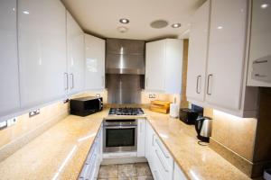 een keuken met witte kasten en een fornuis met oven bij Tower Bridge 2BR apartment for 6 with terrace in Londen