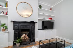 a living room with a fireplace and a mirror at Beautiful & Cosy 1-Bedroom Apartment in Clapham in London