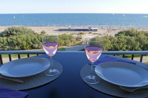 zwei Gläser Wein auf einem Tisch mit Strandblick in der Unterkunft Studio de 33 m2, vue et bord de mer, parking in La Grande-Motte