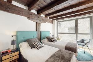 a bedroom with two beds and a window at Casa Rural Ixurkonea in Arbizu