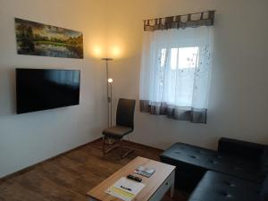 uma sala de estar com um sofá e uma mesa em Ferienwohnung Sonnenschein em Rheinhausen