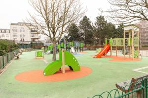 a park with a playground with a tree and slides at Charmant T2 proche de Disney in Noisy-le-Grand