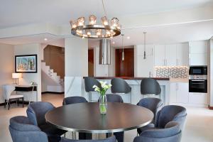 a kitchen and dining room with a table and chairs at The Townhouses The Pearl in Doha