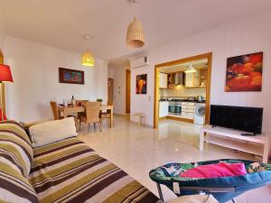 uma sala de estar com um sofá e uma sala de jantar em Apartamento My Sunset T3 by YHA em Cabanas de Tavira