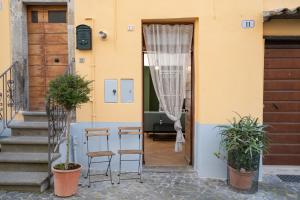 a door to a house with two chairs and plants at Acqua Dolce in Capodimonte