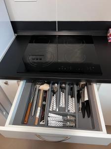 a drawer in a cabinet filled with utensils at Central Metropolitan Bright 1 in Iaşi