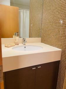 y baño con lavabo y espejo. en Apartamento foz village, en Buarcos