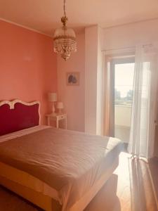 a bedroom with a bed with a chandelier and a window at Apartamento foz village in Buarcos +4 photos