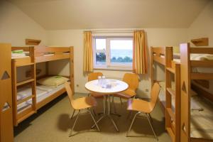 a room with a table and chairs and bunk beds at Jugendherberge Dahme in Dahme