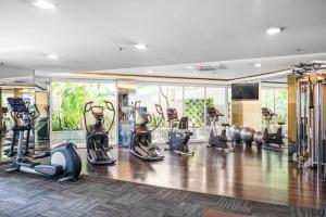 einen Fitnessraum mit Laufbändern und Trainingsgeräten in einem Zimmer in der Unterkunft AIKA by Kozystay Next to Mall in Jakarta