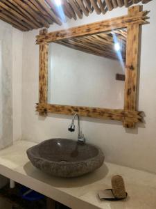 a bathroom with a stone sink and a mirror at Kayu81- Beautiful Pool Vila Ubud Mountain View 2BR in Bedahulu