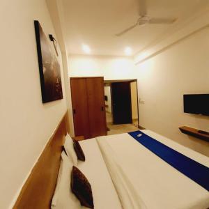 sypialnia z łóżkiem i telewizorem na ścianie w obiekcie Hotel Nisha Nest, Bhopal w mieście Bhopal