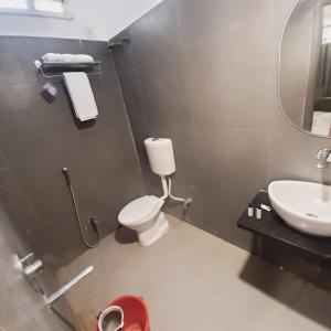 uma casa de banho com um WC e um lavatório em Hotel Nisha Nest, Bhopal em Bhopal