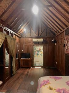 a room with a bed and a tv on a wooden ceiling at Kayu81- Beautiful Pool Vila Ubud Mountain View 2BR in Bedahulu