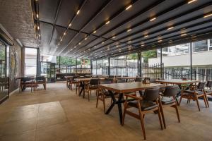 ein Restaurant mit Tischen, Stühlen und Fenstern in der Unterkunft ALEE BEYZAR Hotel in Ankara
