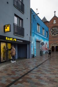 a person standing in front of a blue building at Bank Square Town House in Belfast