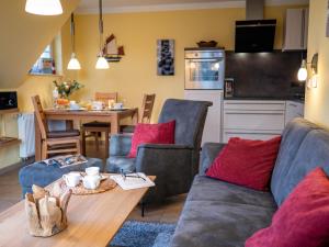 a living room with a couch and a table and a kitchen at Villa Arielle, FW 5 in Zingst