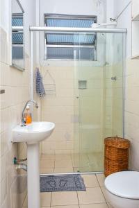 a bathroom with a shower and a sink and a toilet at cantinho jardim in Santos