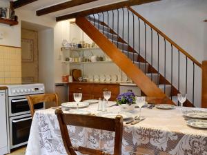 a kitchen with a table with plates and wine glasses at Bridge End Cottage in Cregrina