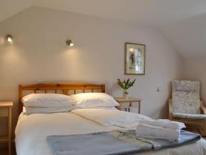 a bedroom with a bed with two towels on it at Bridge End Cottage in Cregrina