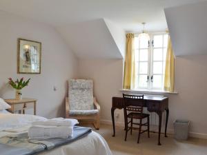 CregrinaにあるBridge End Cottageのベッドルーム1室(ベッド1台、デスク、椅子付)