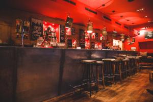 a bar with a row of bar stools at Tante ALMA Bristol Hotel in Frankfurt