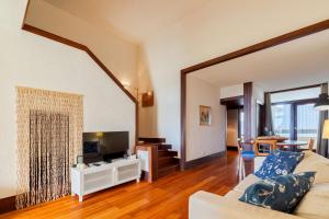 a living room with a couch and a tv at Apartamento Troia in Troia