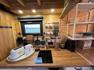 eine Küche mit einer Theke, einer Mikrowelle und einem Herd in der Unterkunft Tiny House 