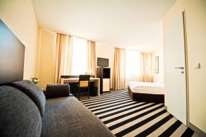 a hotel room with a bed and a desk at Tante ALMA Bristol Hotel in Frankfurt