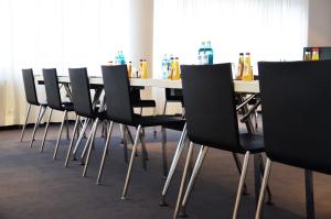 una fila de sillas negras alrededor de una mesa blanca en Bristol Hotel - Frankfurt City, en Frankfurt