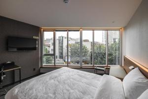 Postel nebo postele na pokoji v ubytování Pillowsopher Hongdae