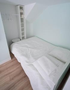 - un lit blanc avec des draps blancs dans une chambre dans l'établissement Appartement neuf tout confort à Blaye proche de la Citadelle, à Blaye