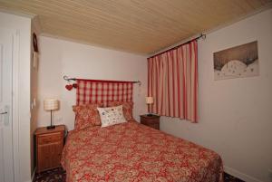a bedroom with a bed and a red curtain at Chalet Mokus in Les Allues