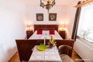 - une chambre avec un lit et une table avec un bol vert dans l'établissement PENSIUNEA BORDÁS PANZIÓ, à Sfântu-Gheorghe