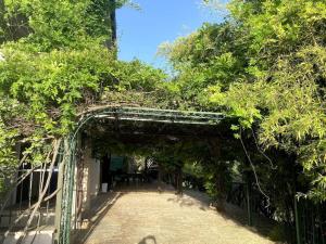 ein Torbogen mit Bäumen in der Mitte einer Straße in der Unterkunft Villa Panoramica con piscina in Castelnuovo di Farfa