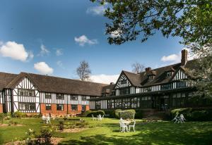 a large black and white building with animals in the yard at Hogarths Stone Manor in Kidderminster