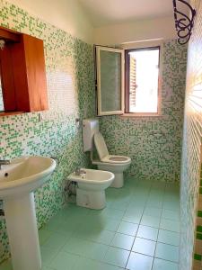 a bathroom with a sink and a toilet and a window at Lianna Beach Resort in Marina di Montenero