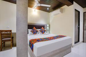 a bedroom with a bed and a chair at FabHotel New Prince Palace in Mumbai
