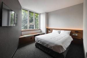 Postel nebo postele na pokoji v ubytování Pillowsopher Hongdae